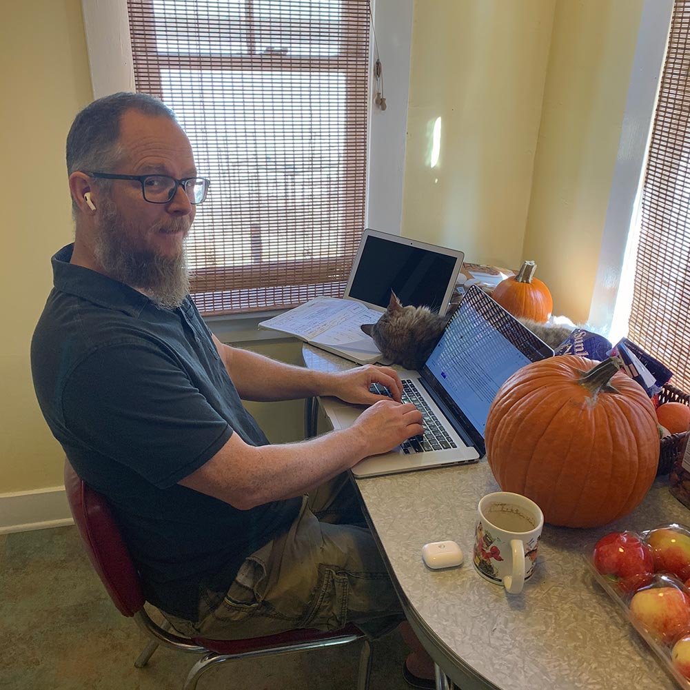 Dean sitting at a table with laptop prepping for a user interview.